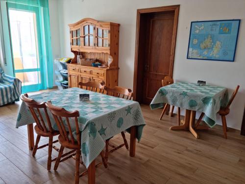 un comedor con 2 mesas, sillas y una mesa en Camera Smeraldo, en La Maddalena