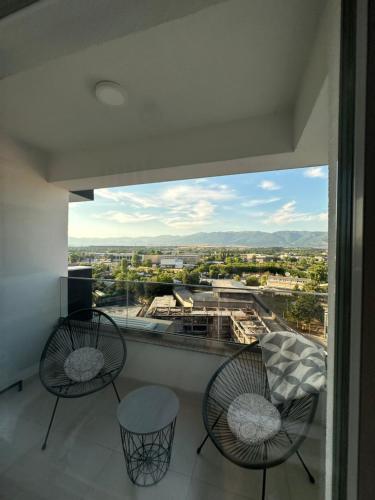 a balcony with two chairs and a view of a city at Apartments Jana in Skopje