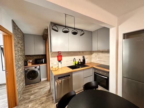 a kitchen with a sink and a table with chairs at Casa da Ribeira in Vila do Bispo