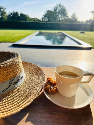 a cup of coffee and a hat sitting on a table at De verloren hoek in Aarschot
