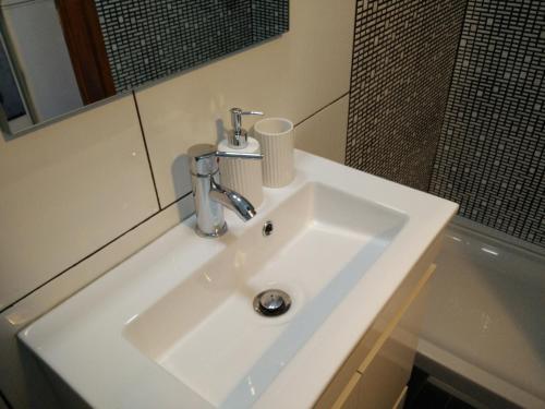 un lavabo blanc dans une salle de bain avec un miroir dans l'établissement Xavier - Alfama Apartment River View, à Lisbonne