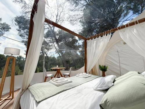 - un lit dans une chambre avec tente dans l'établissement La Bulle des Pins, à Istres