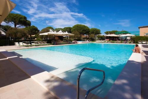 a large swimming pool with a woman standing in it at Resort Capalbio in Capalbio