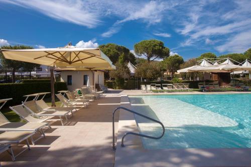 a swimming pool with lounge chairs and an umbrella at Resort Capalbio in Capalbio