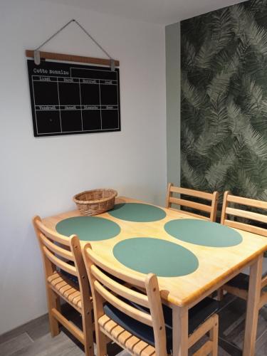une table de salle à manger avec quatre chaises et un tableau noir dans l'établissement La Salamandre, à Saint-Côme-de-Fresné