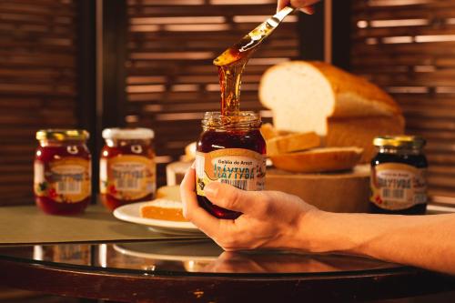 a person holding a jar of peanut butter and jelly at Hotel Fazenda Itáytyba in Tibagi