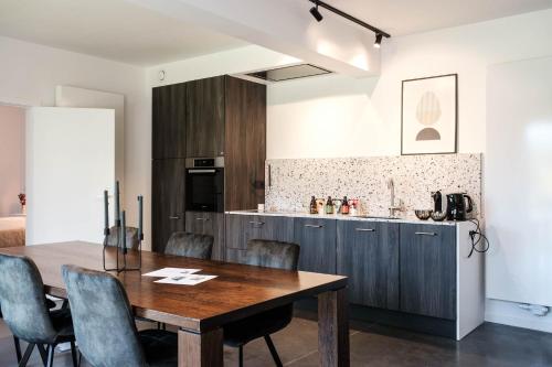 a kitchen and dining room with a wooden table and chairs at De verloren hoek in Aarschot