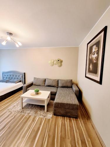 a living room with a couch and a table at Klaipėda Apartament in Klaipėda