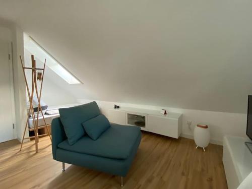 a living room with a blue chair and a fireplace at Altstadt-Apartment in Bad Laasphe