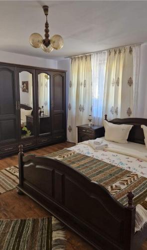a bedroom with a large bed and a mirror at Pensiunea Casa Godja in Văleni