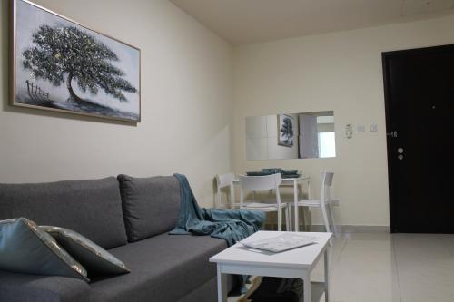 a living room with a couch and a table at Newly furnished 1 Bedroom, high floor, amazing view, close to metro in Dubai