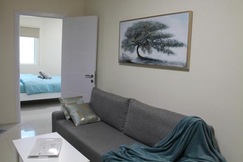 a living room with a couch and a picture on the wall at Newly furnished 1 Bedroom, high floor, amazing view, close to metro in Dubai
