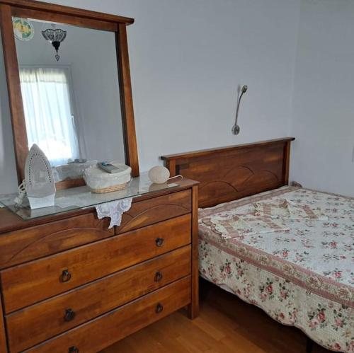 a bedroom with a dresser with a mirror and a bed at Villa Filippa Chora luxury & cozy in Kithnos