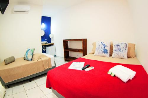 a room with a bed with a red blanket at Pousada Oceano e Mar in Ilhabela