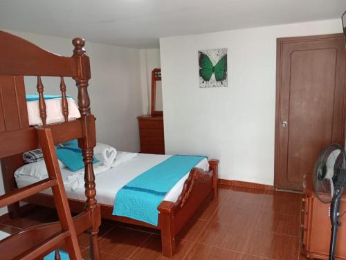 a bedroom with a bed and a wooden bunk bed at Hotel Campestre Alto Bonito del Quindío in El Cuzco