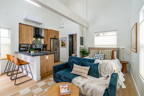 a living room with a blue couch and a kitchen at Swanky Studio in Vibrant Hillcrest in San Diego