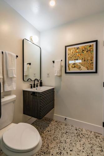 a bathroom with a toilet and a sink and a mirror at Swanky Studio in Vibrant Hillcrest in San Diego