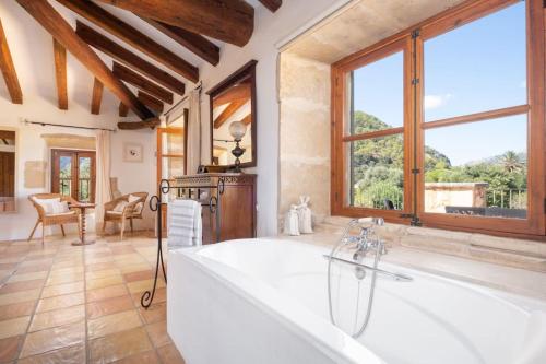 baño grande con bañera y ventana grande en Can Sion Finca, en Pollensa