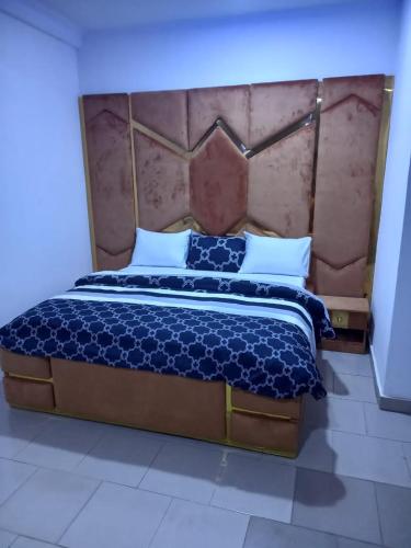 ein Schlafzimmer mit einem großen Bett mit großem Kopfteil in der Unterkunft Mega Pavilion Apartment Gwarinpa in Gwarinpa