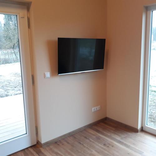 a living room with a flat screen tv on the wall at Weserberglandalm Haus 3 in Ottenstein