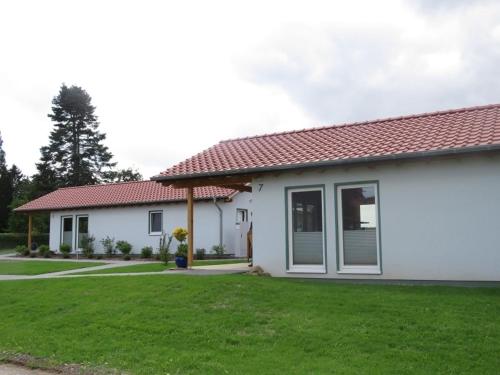 a house with a green lawn in front of it at Weserberglandalm Haus 3 in Ottenstein