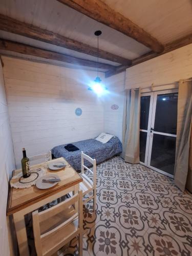 a room with a bed and a table in a room at Posada Malbec in Uspallata