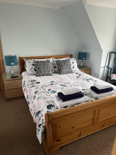 a bedroom with a large bed with a wooden frame at Salmon House in Stornoway