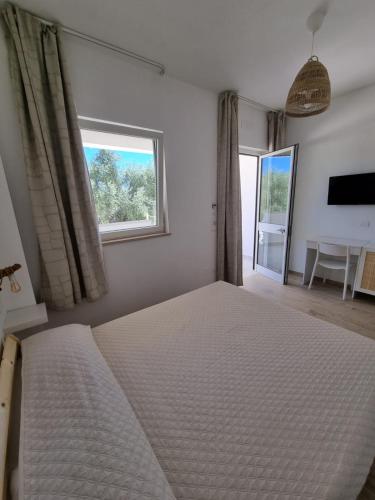 a bedroom with a large bed and a window at Le Fronde Vieste in Vieste