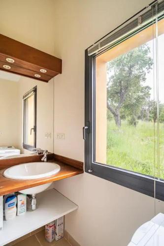 une salle de bain avec un lavabo et une grande fenêtre dans l'établissement Belle villa entre mer et montagne, Argelès-sur-mer, à Argelès-sur-Mer