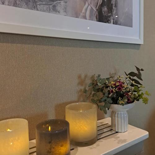 two candles on a table with a vase of flowers at Hotell Rådhuset in Lidköping