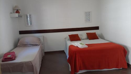 a bedroom with two beds and a red blanket at Biomas Hotel in Brotas