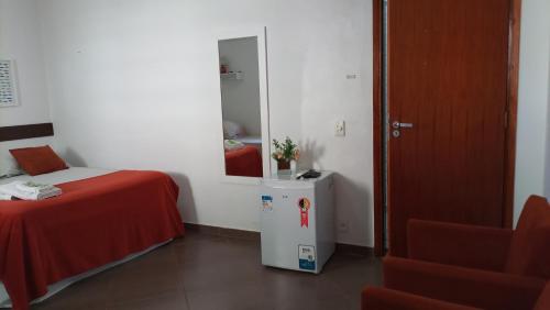 a room with a bed and a chair and a mirror at Biomas Hotel in Brotas