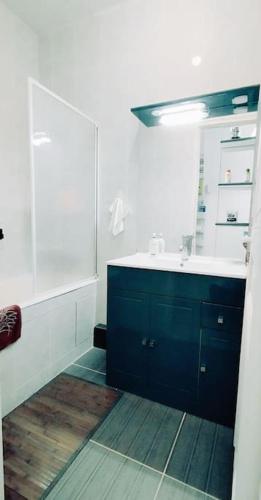 une salle de bain avec un lavabo bleu et un miroir dans l'établissement Eloflat, à Levallois-Perret