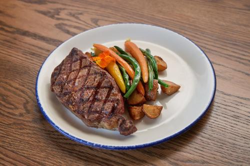 a plate of steak and vegetables on a table at Surfsand Resort in Cannon Beach