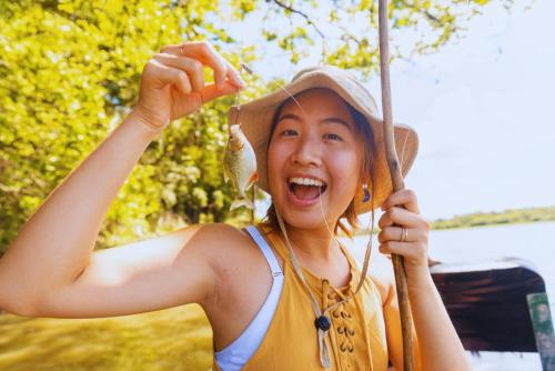 a woman is holding an umbrella and laughing at Amazon Curassow Lodge and Expeditions in Paraíso
