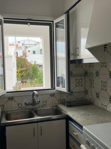 a kitchen with a sink and two windows at Es Grau Lamorino in Es Grau