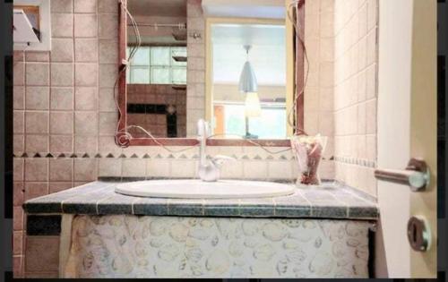 a bathroom with a sink and a mirror at Lefkada Eli's amazing beach house in Nikiana