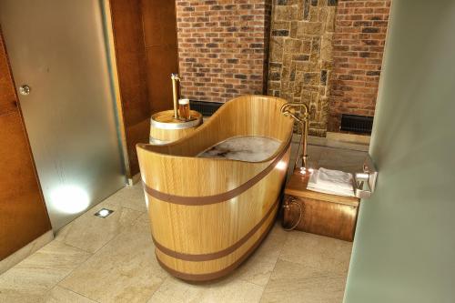 a wooden tub in a bathroom with a toilet at Hotel Purkmistr in Plzeň