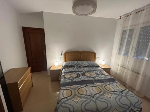 a bedroom with a bed and two night stands at Atico in Tomelloso