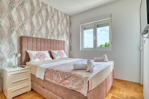 a bedroom with a large bed and a window at Azure Apartments in Budva