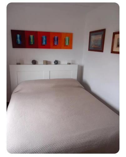 a bed in a bedroom with some pictures on the wall at Casa Pierina in Anacapri