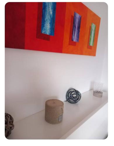 a painting above a white bath tub with a basket at Casa Pierina in Anacapri