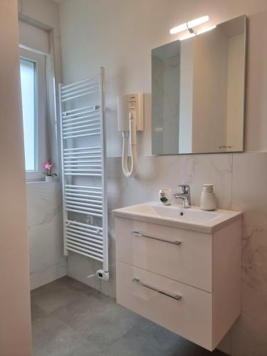 a bathroom with a sink and a mirror and a shower at Crystal Apartment Umag in Umag
