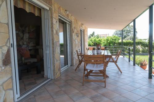 a patio with a table and chairs on a balcony at Luxury Beach Villa in Skála