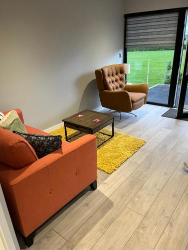 a living room with a couch and a chair at The Carranstown Lodge in Duleek