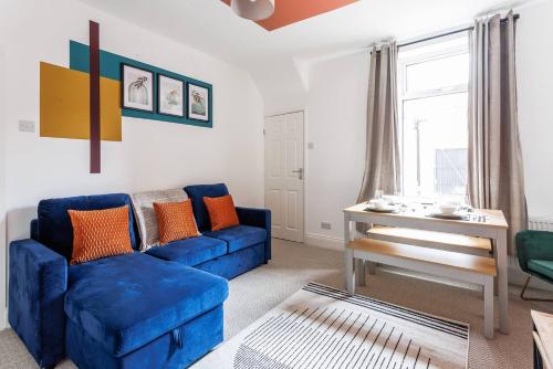 a living room with a blue couch and a table at Homey 4 BR near the city Gateshead&Newcastle in Dunston