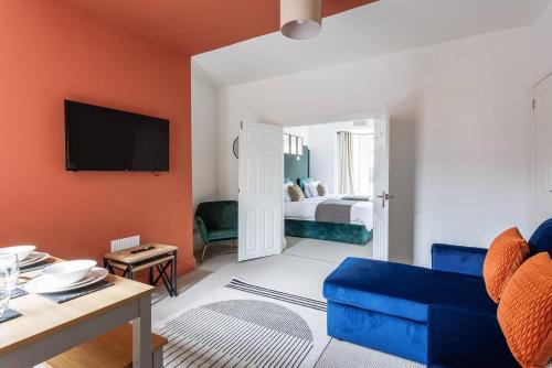 a living room with a blue couch and a bedroom at Homey 4 BR near the city Gateshead&Newcastle in Dunston