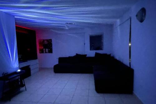 a living room with a couch and a room with blue lights at Casa Campo Alegre in Bayamon