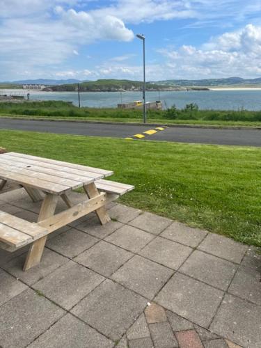 a wooden picnic table sitting on a sidewalk next to a street at 10 Harbourside in Downings