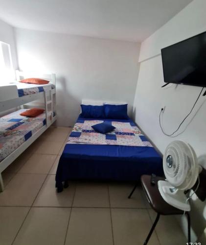 a small bedroom with a bed and a fan at Hostel & Pousada SANTOS PRAIA in Santos